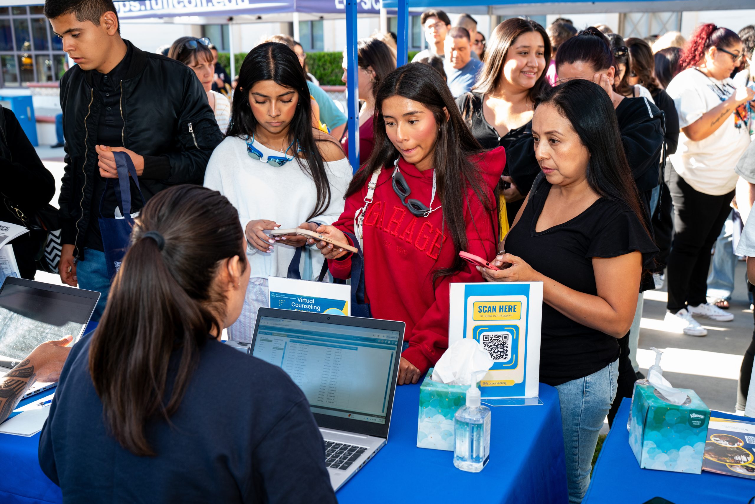Three female students listen to a Fullerton College staff member.
