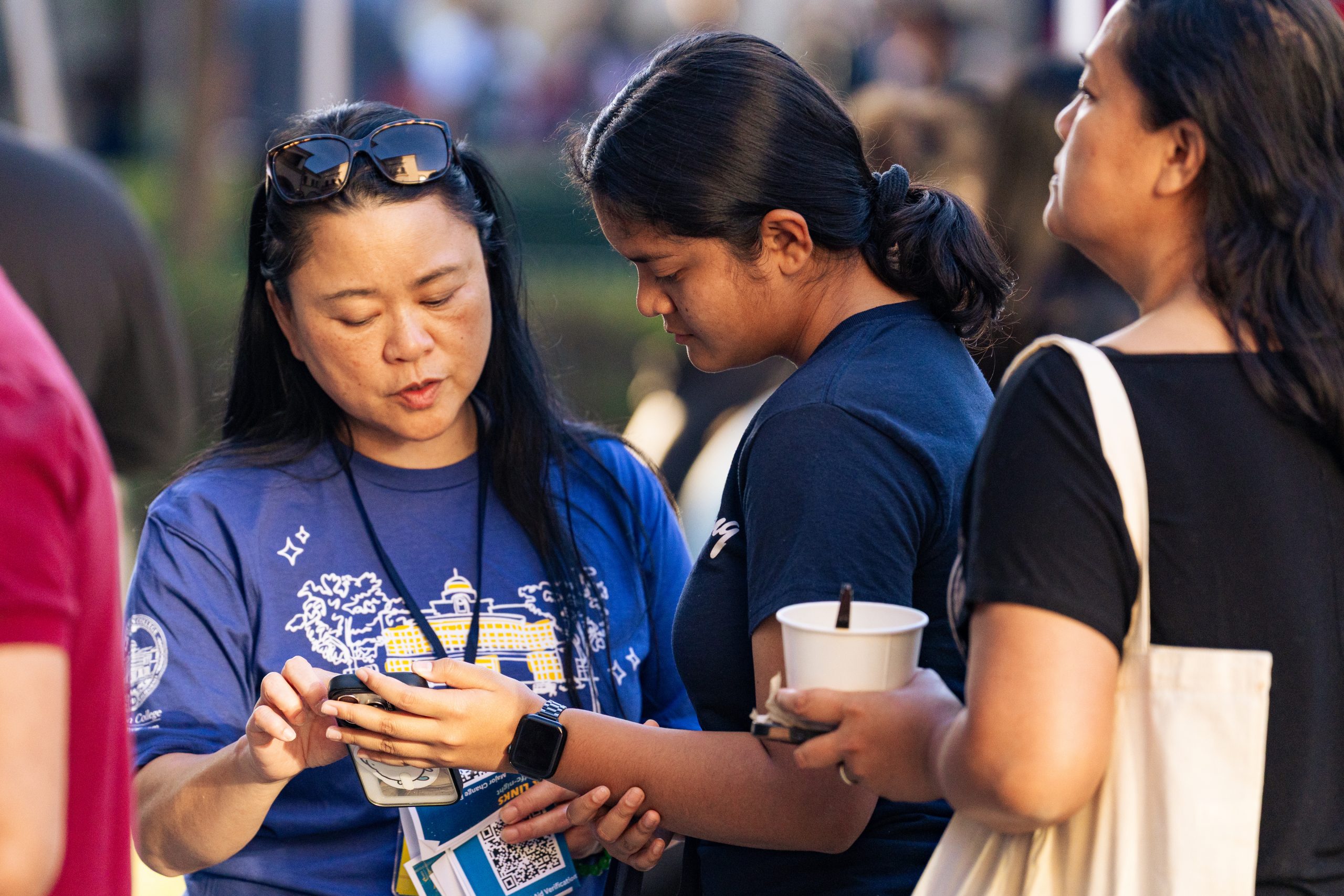 A female Fullerton College staff member assists a female student with a question.