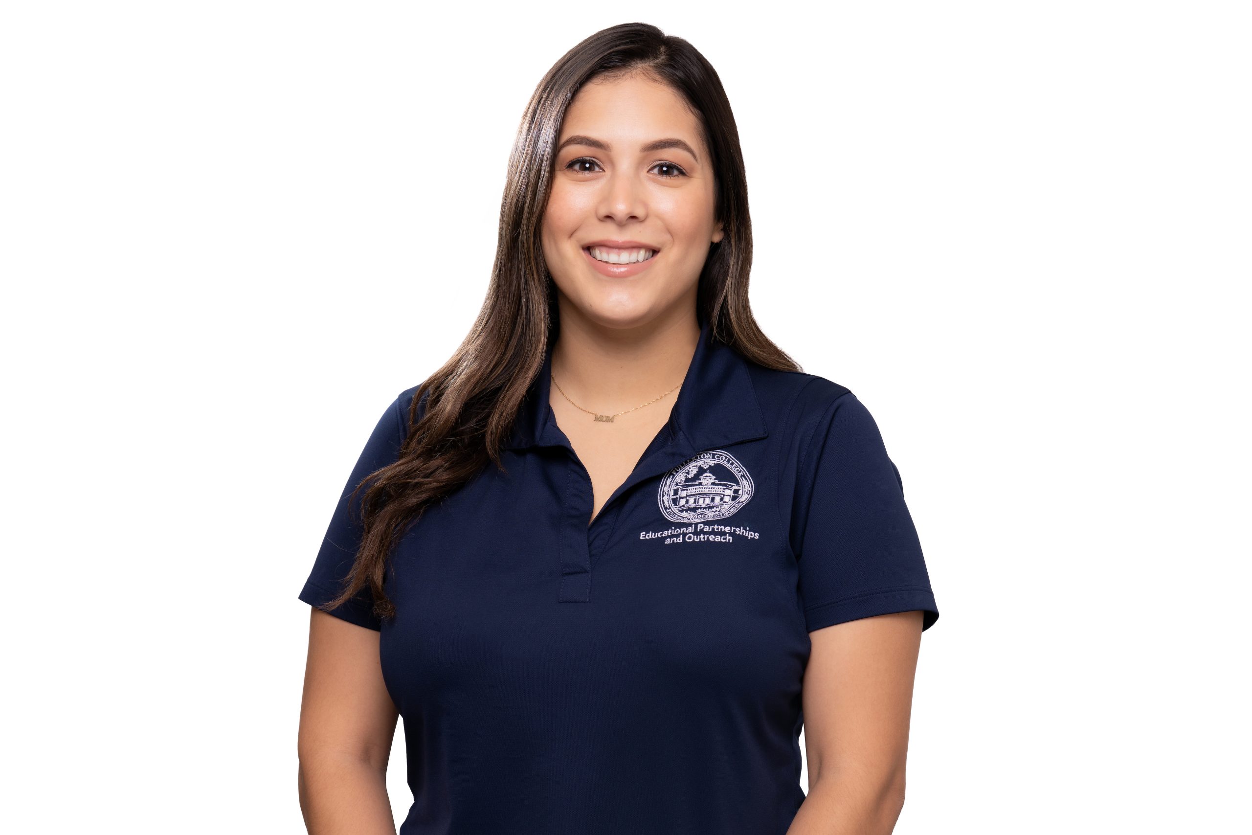 A smiling person with long dark hair wears a navy blue polo shirt featuring an embroidered logo and text that reads "Educational Partnerships and Outreach."